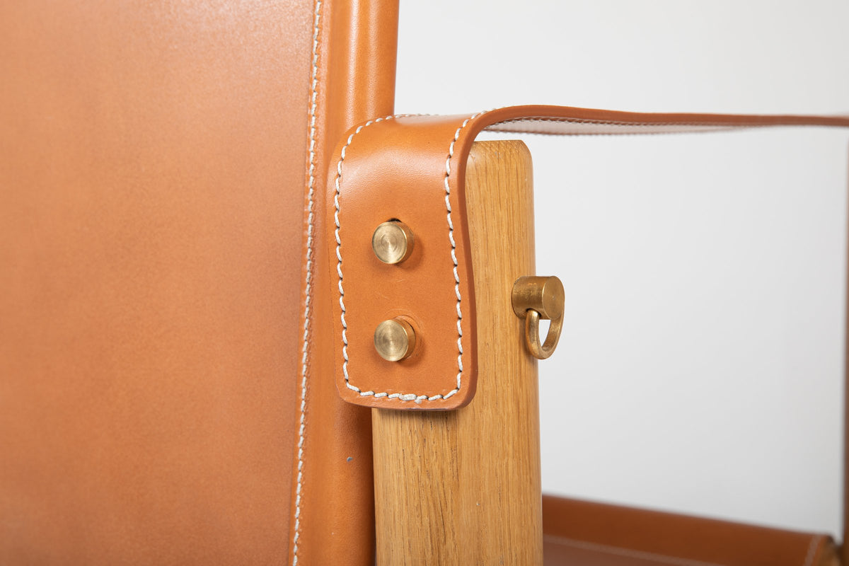 Detail of the leather armrest and brass buckle on the Cubica armchair