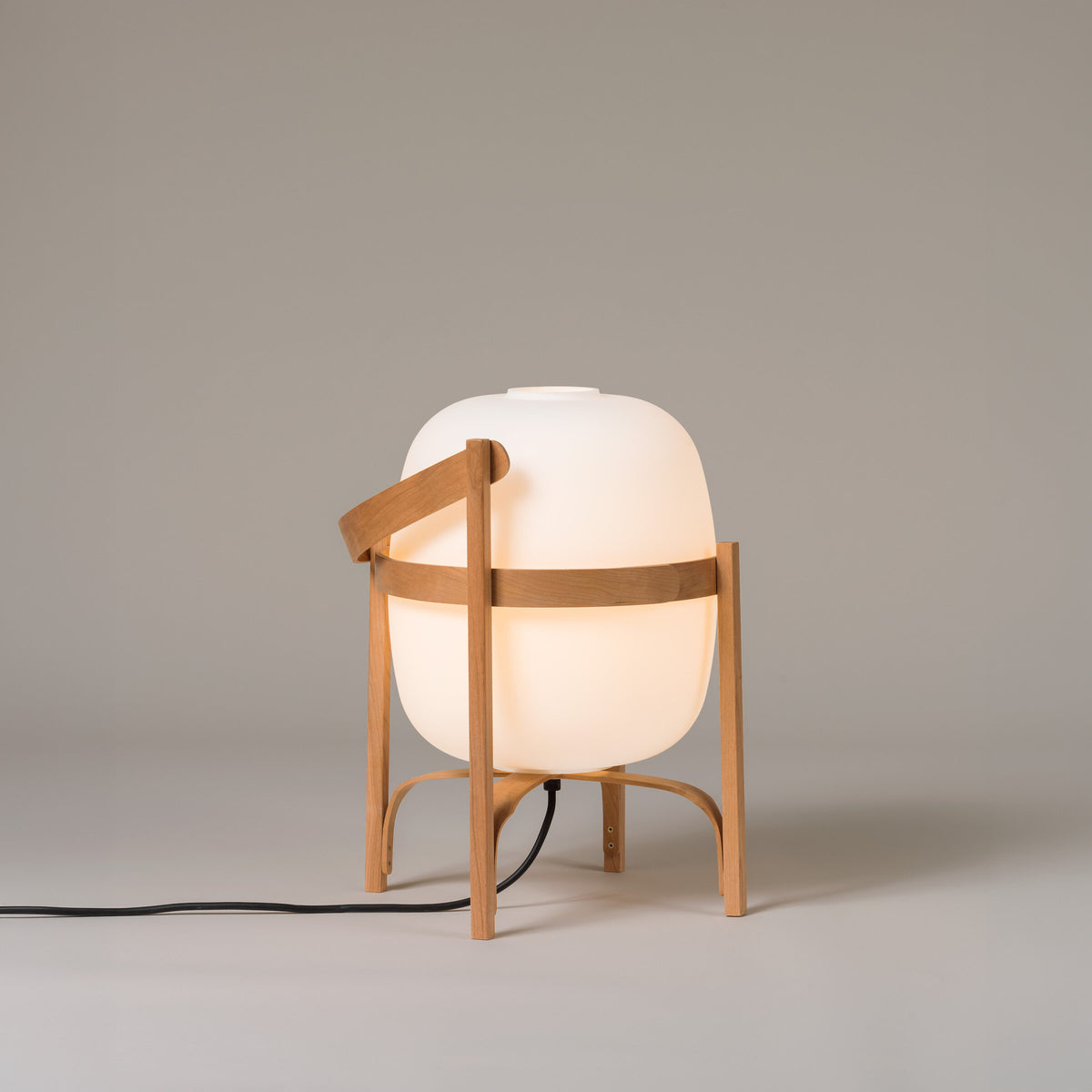 Cesta lamp with its handle folded down, switched on