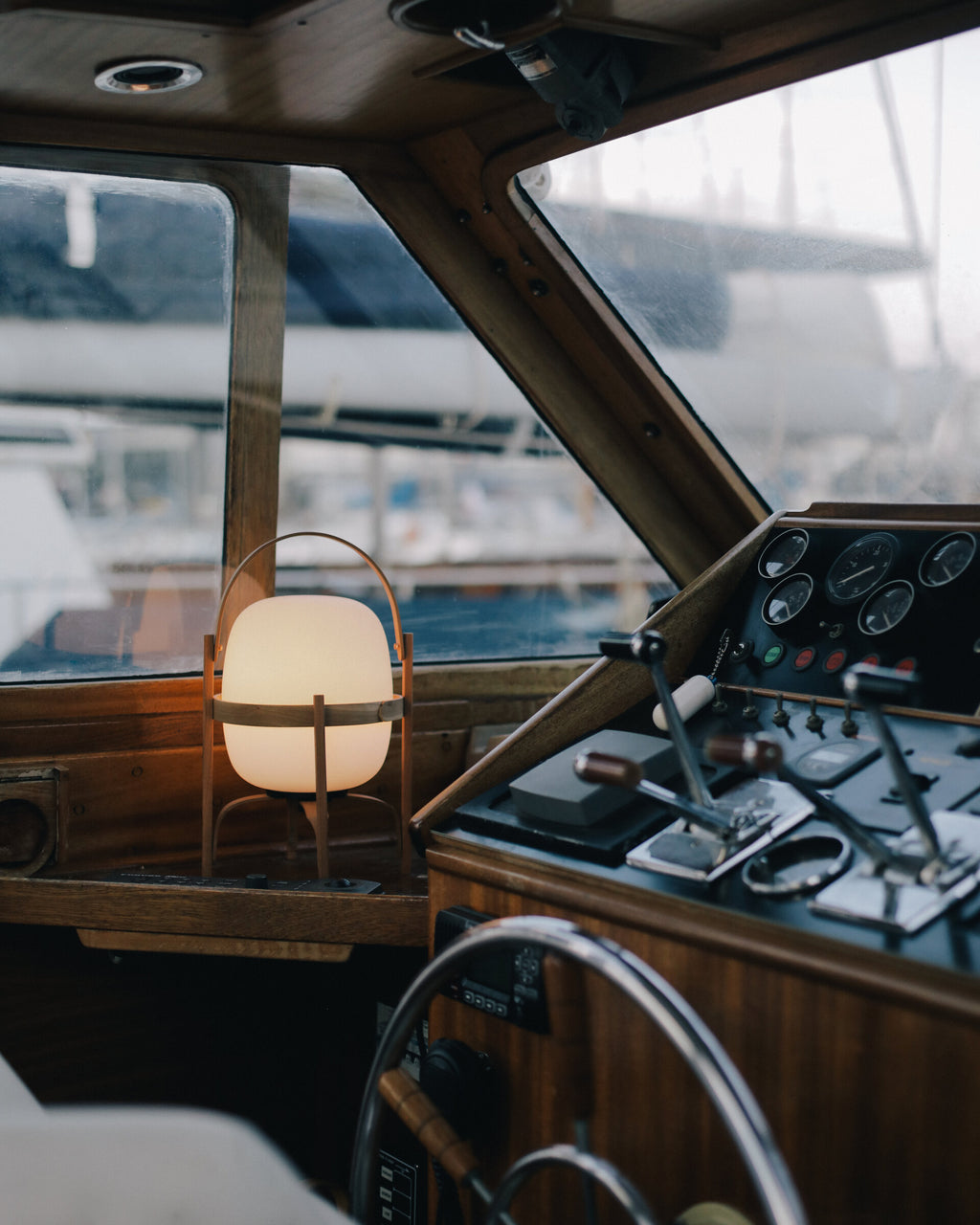 Cestita Batería portable lamp beside the helm of a wooden boat