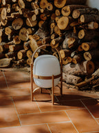 Cestita Batería portable lamp in front of stacked firewood at Casa Ugalde