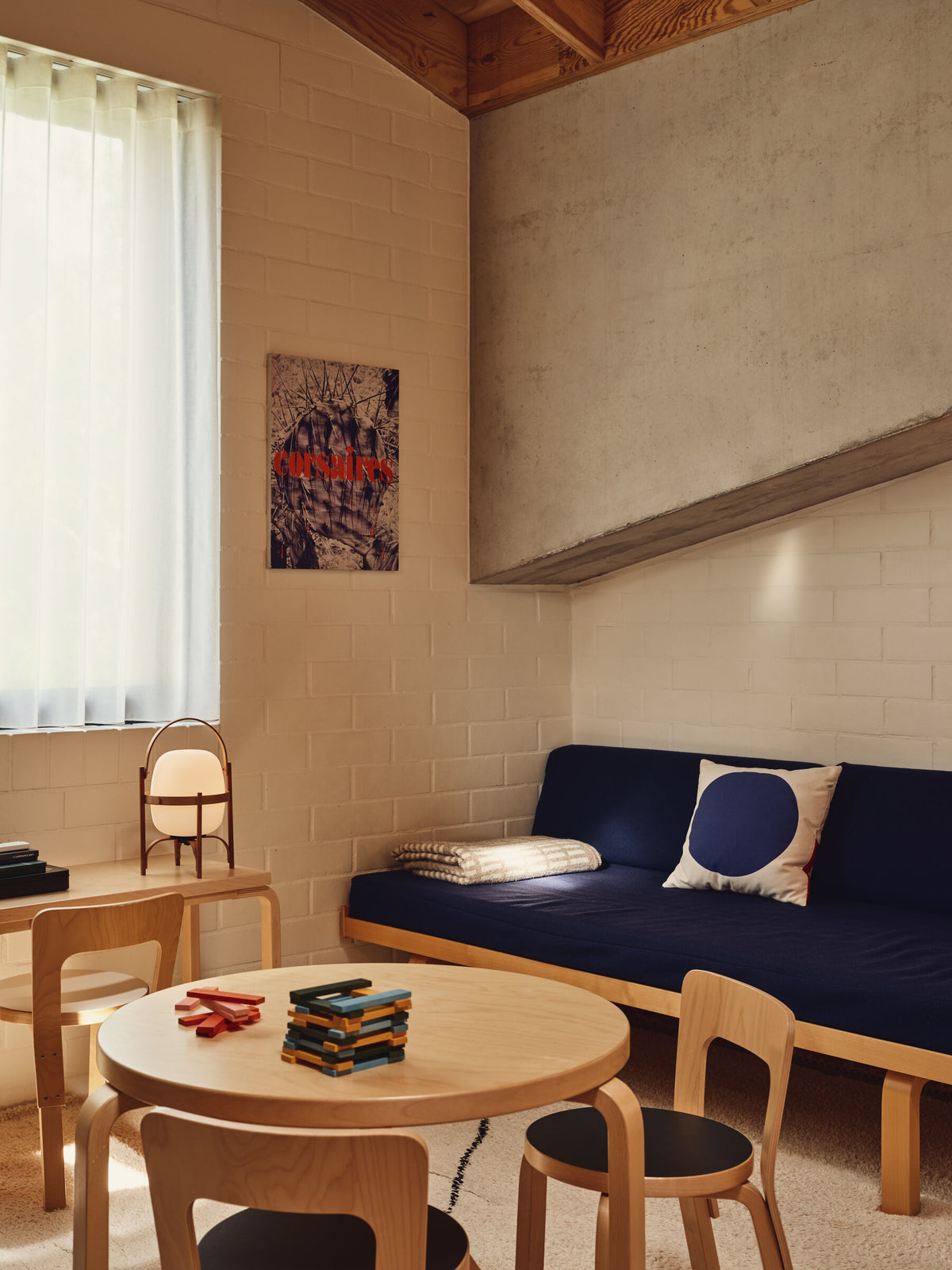 Cestita Batería portable lamp in a living room with a blue sofa and round table