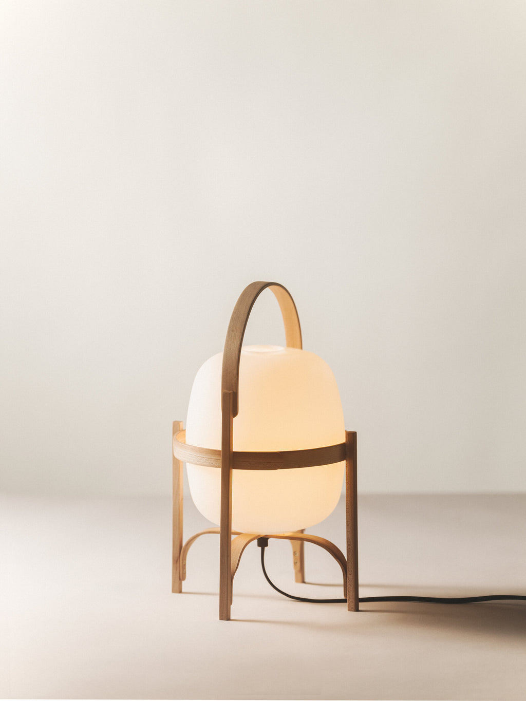 Cestita lamp by Miguel Milá for Santa & Cole in cherry wood with an opal globe, switched on
