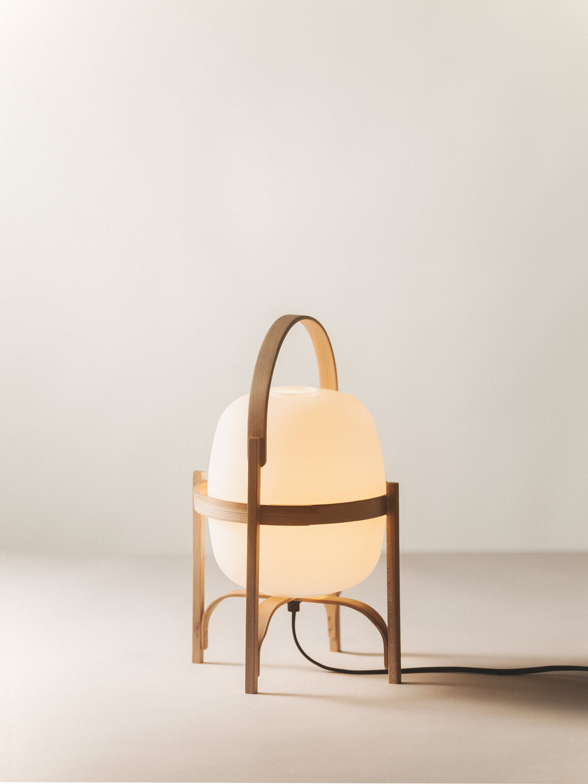 Cestita lamp by Miguel Milá for Santa & Cole in cherry wood with an opal globe, switched on