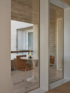 Ramón chair in natural rattan at a round table, seen through a doorway