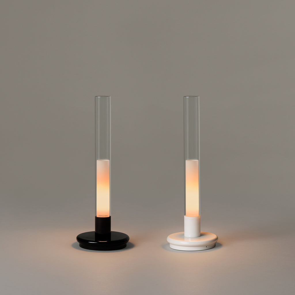 Black and white Sylvestrina portable lamps side by side, switched on