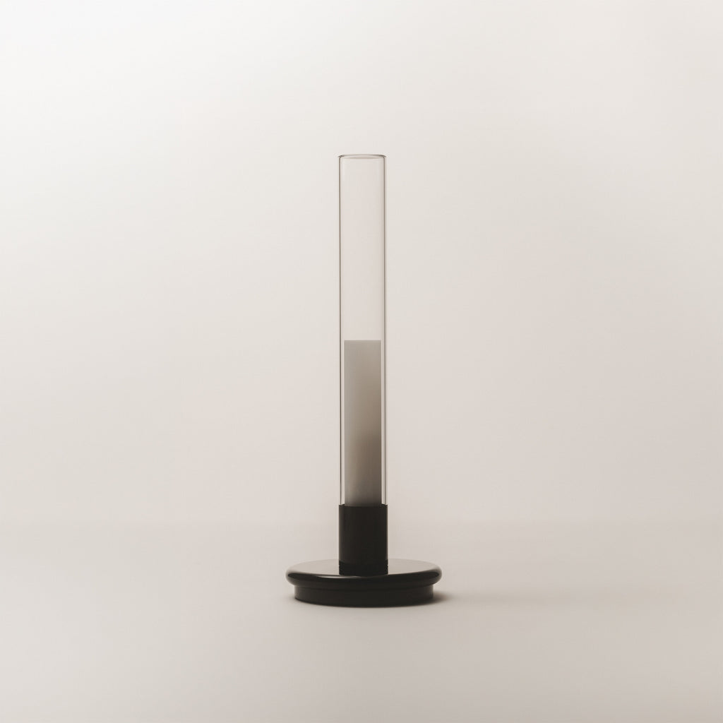 Black Sylvestrina portable lamp on a white surface, switched off