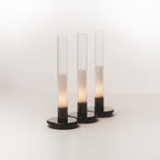 Three black Sylvestrina portable lamps switched on