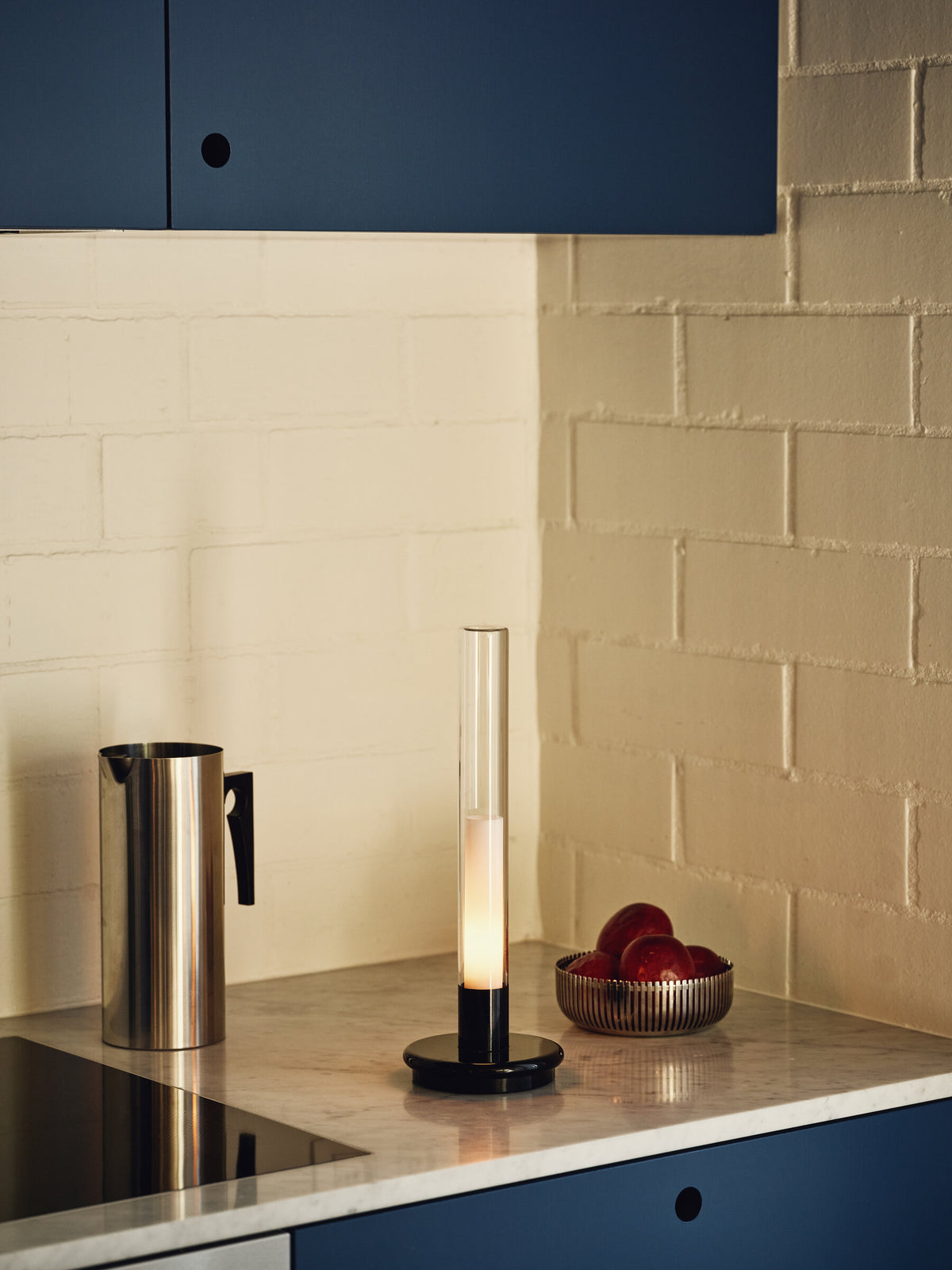 Sylvestrina portable lamp on a kitchen worktop beside a steel jug