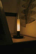 Sylvestrina portable lamp glowing on a table in a dark room